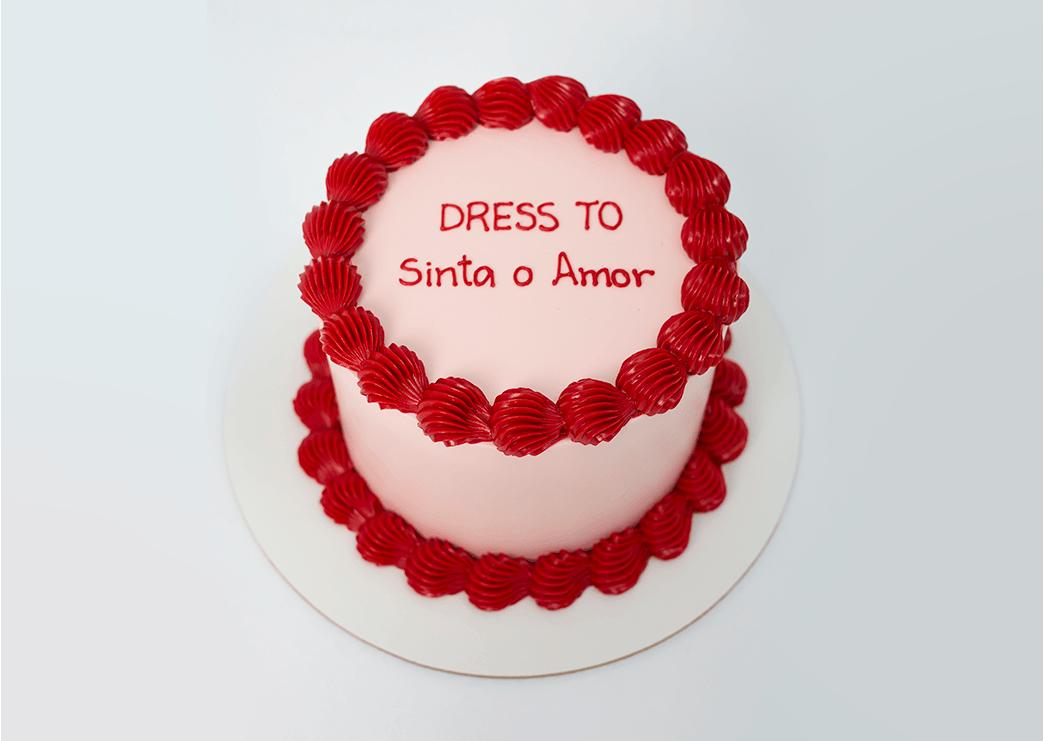 Banner de bolo confeitado  na cor branco e vermelho, com a mensagem: "Dress To, Sinta o amor".