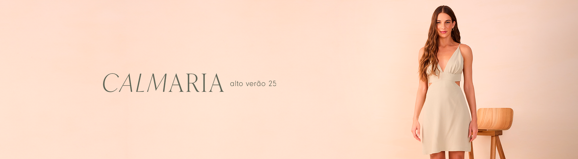 mulher usando um vestido claro com alças finas, posando ao lado de uma cadeira de madeira contra um fundo bege suave. Ao lado dela, à esquerda, está o título 'CALMARIA' em letras finas e elegantes, seguido pelo texto 'alto verão 25'. A imagem transmite um estilo minimalista, suave e sereno, refletindo a sensação de calma e tranquilidade da coleção de moda.