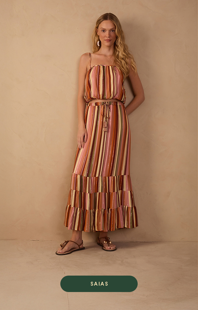 Banner da Dress To com fundo bege texturizado. Modelo usa conjunto verde-oliva com estampa de folhas brancas. A blusa de um ombro só combina com a saia reta da mesma estampa. Abaixo, botão verde com a palavra "SAIAS".