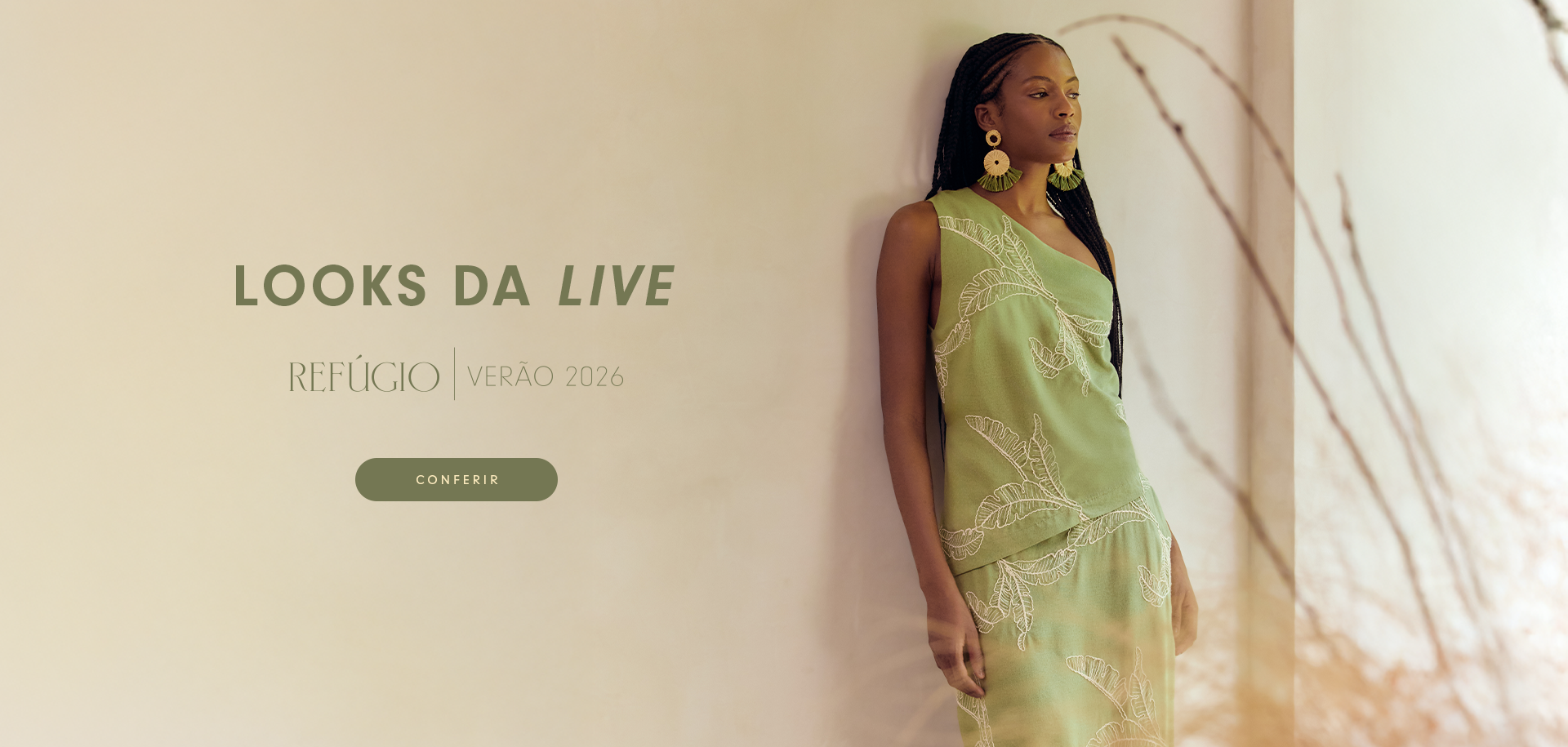 Banner da coleção "Refúgio Verão 2026", com destaque para os "Looks da Live". Mulher negra com tranças posa com vestido verde bordado ao lado direito da imagem. Do lado esquerdo, sobre fundo bege claro, há o nome da coleção e um botão verde com a palavra "Conferir".