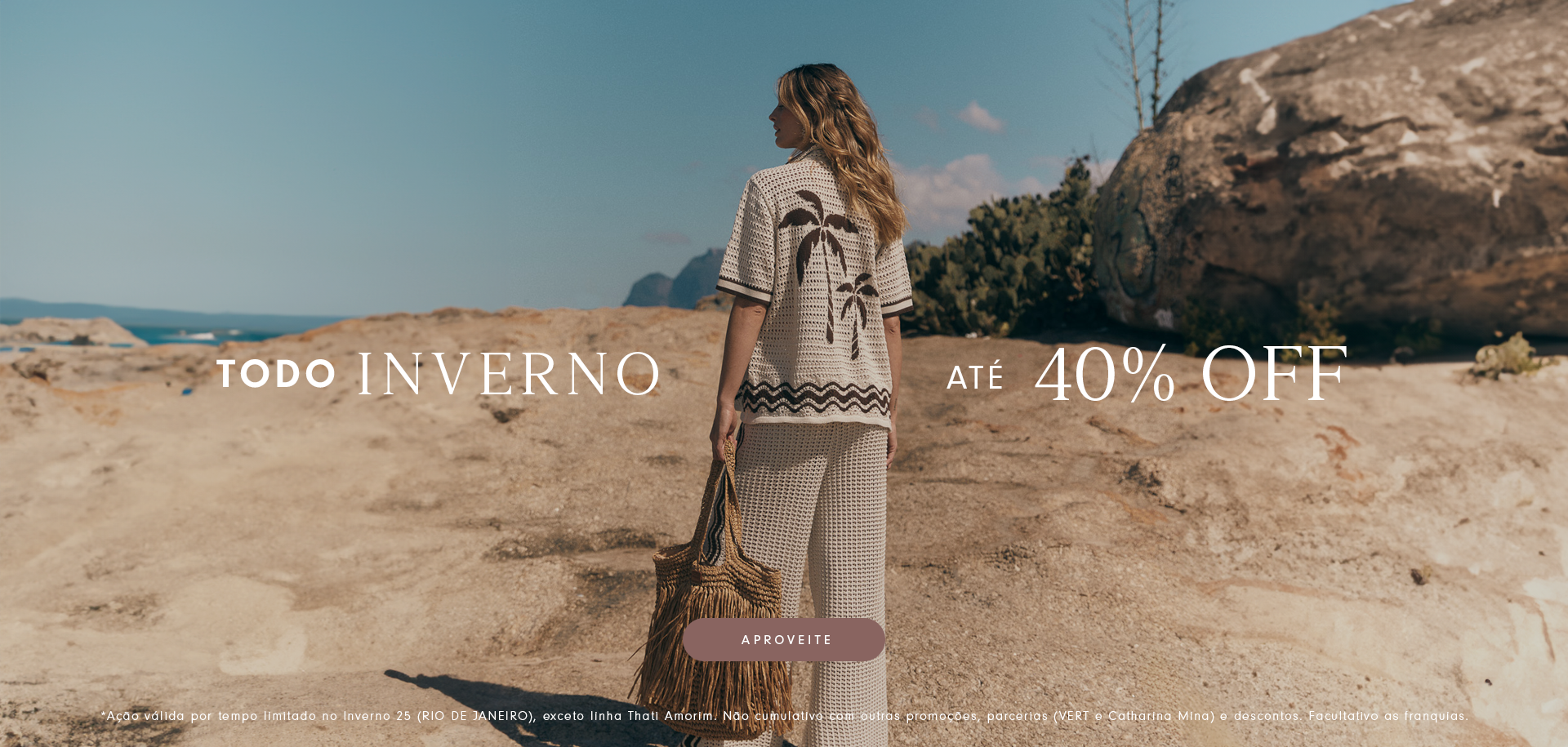 Mulher de costas caminhando por paisagem de pedras, vestindo conjunto de tricô bege com estampa de coqueiros, segurando bolsa de palha. Texto: 'Todo inverno até 40% OFF'. Botão escrito 'Aproveite'.