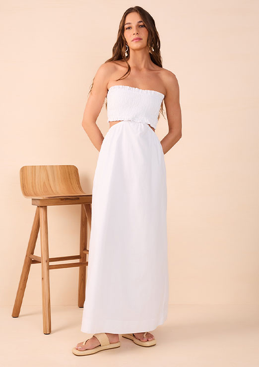 Modelo morena usando vestido longo tomara que caia na cor branco da nova coleção de alto verão 25 da Dress To.