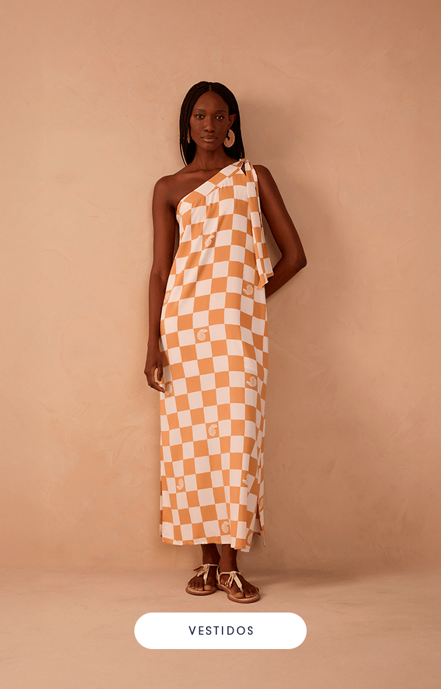 Modelo feminina contra fundo bege, usando vestido longo de alças finas. A peça apresenta estampa listrada diagonal em azul claro e branco, com fenda lateral.