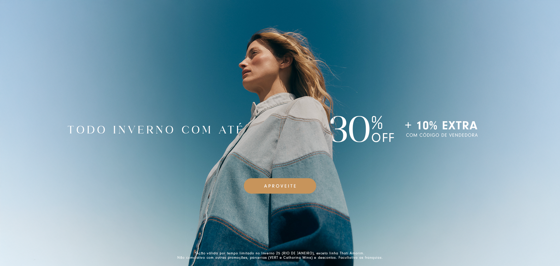 Mulher usando casaco jeans em tons claros e escuros, olhando para o horizonte sob um céu azul. Texto promocional diz 'Todo inverno com até 30% off + 10% extra com código de vendedora'. Botão laranja com a palavra 'Aproveite'.