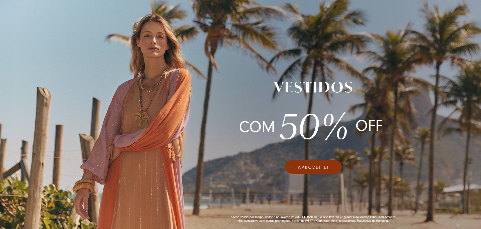 Banner promocional em cenário de praia com modelo loira vestindo um look leve em tons de laranja e rosa, com colares e pulseiras. Ao lado direito da imagem está o texto "VESTIDOS - ATÉ 50% OFF" com botão "Aproveite!". Ao fundo, palmeiras e montanhas completam o visual tropical. Texto de rodapé detalha as condições da promoção.