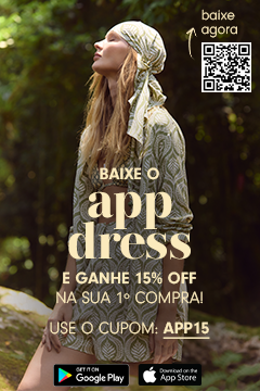 Banner promocional da marca Dress To com fundo de floresta iluminada. Modelo loira usa vestido estampado e lenço na cabeça, olhando para o alto. O texto central destaca: “Baixe o app Dress e ganhe 15% off na sua 1ª compra! Use o cupom: APP15”. No canto superior direito, há um QR Code com o texto “baixe agora” e, na parte inferior, os botões das lojas Google Play e App Store.