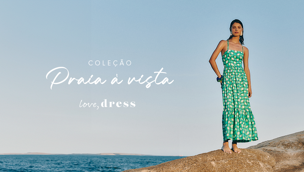 Modelo na praia, com vestido longo estampado da coleção Praia à Vista Love, Dress.