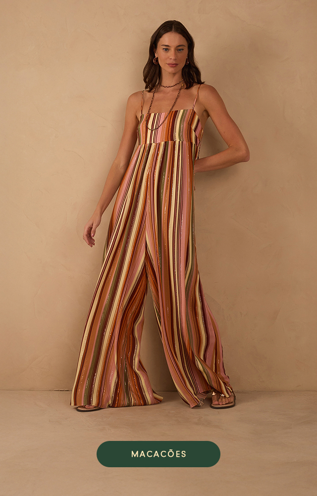 Banner da Dress To com fundo neutro. Modelo loira usa conjunto verde de alfaiataria com blazer oversized e top cropped por baixo, ambos com corte elegante e contemporâneo. Abaixo, botão verde com a palavra "CASACOS".