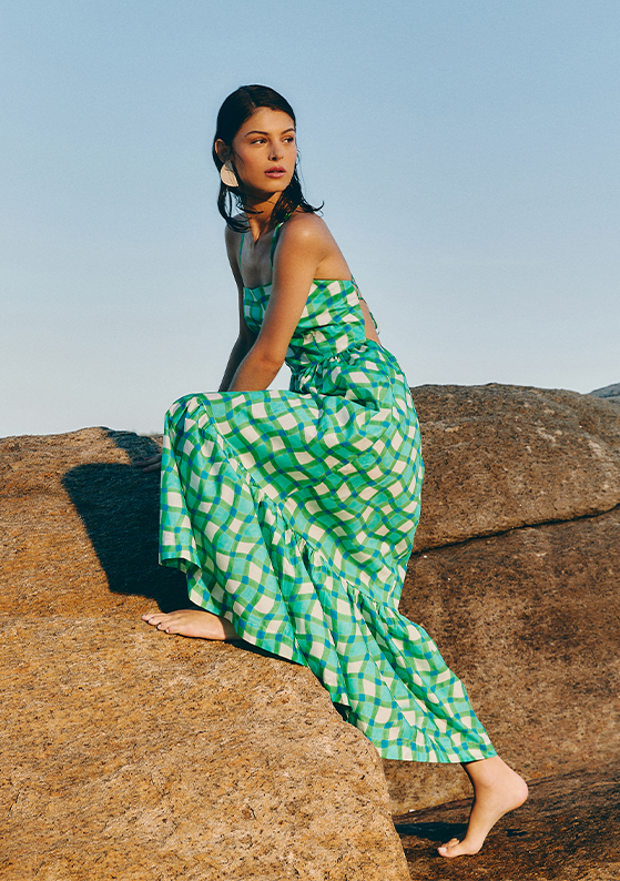 Modelo na praia utilizando vestido longo estampado na cor verde e branco, da coleção Love Dress.